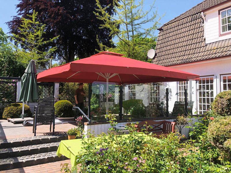 Gartenterrasse mit großem Sonnenschirm am Haus