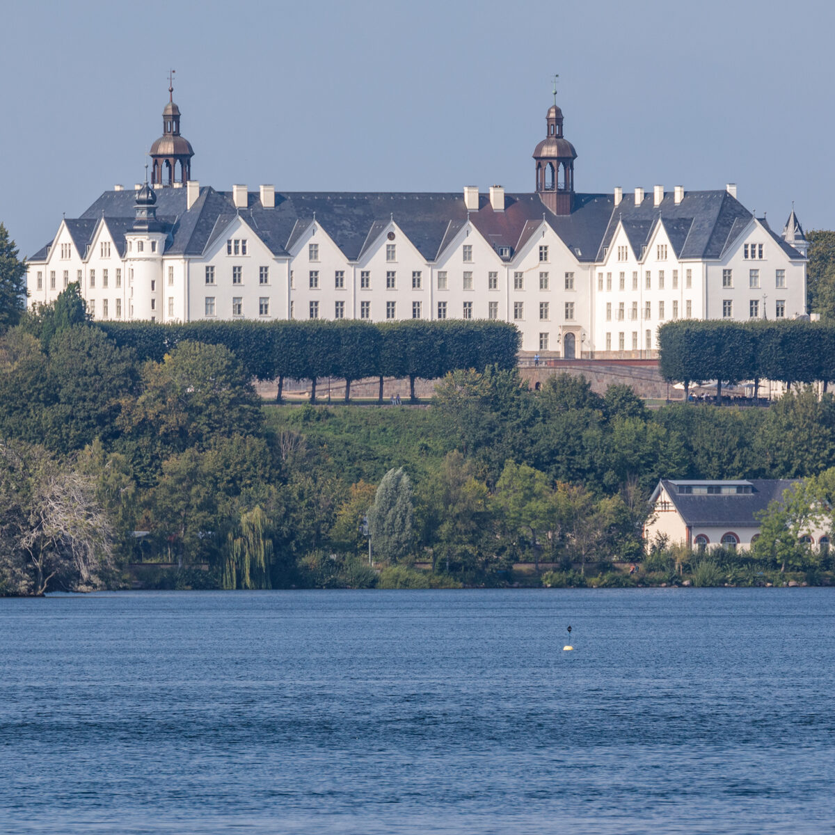 Schloss Plön über dem bewaldeten Ufer des Großen Plöner Sees